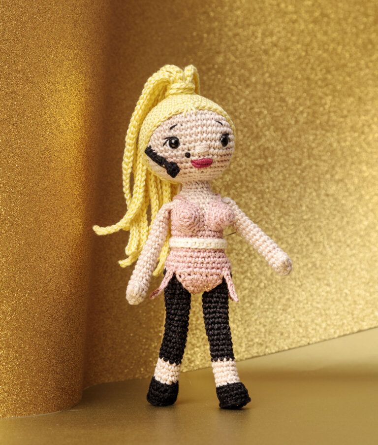 inszeniertes Foto einer Madonna Häkelpuppe auf einer Bühen mit goldenem Hintergrund für ein Promi-Häkelbuch