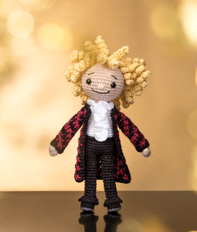 inszeniertes Foto einer Thomas Gottschalk Häkelpuppe auf einer Bühne mit angedeuteter Bühnenbeleuchtung für ein Promi-Häkelbuch