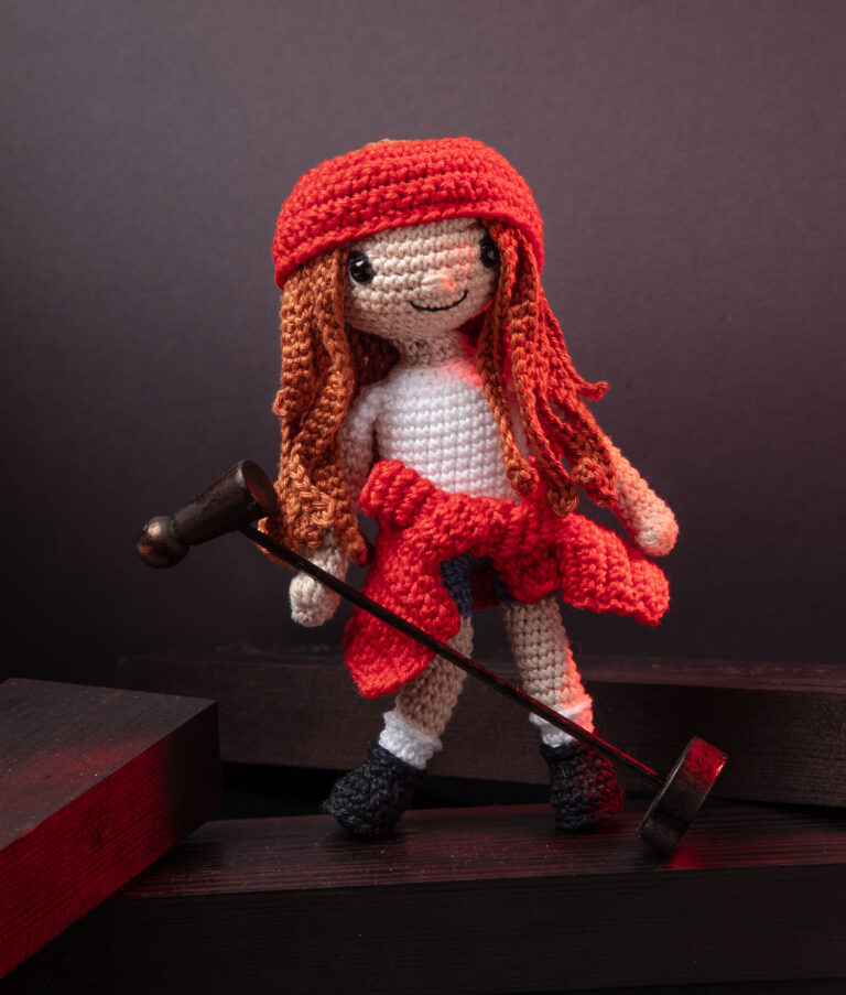 inszeniertes Foto einer Axl Rose Häkelpuppe auf einer Bühne in einer ihm typischen Pose für ein Promi-Häkelbuch