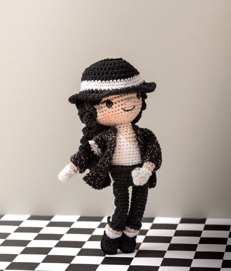 inszeniertes Foto einer Michael Jackson Häkelpuppe auf einem karierten Fliesenboden in typischer Tanzpose für ein Promi-Häkelbuch